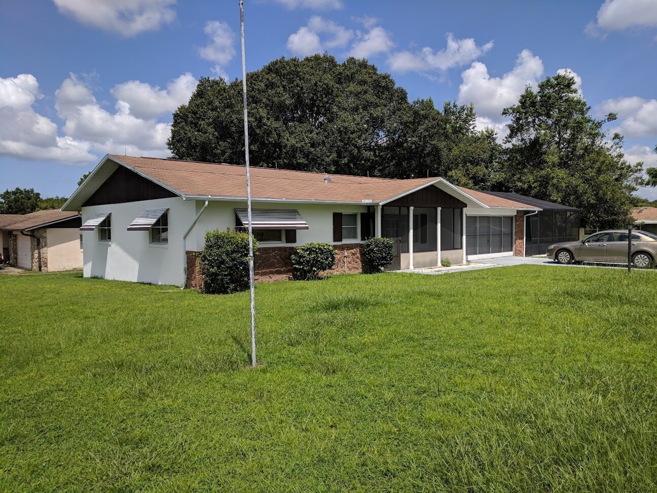 Single-story ranch home with a screened porch on a grassy lot in Beverly Hills.
