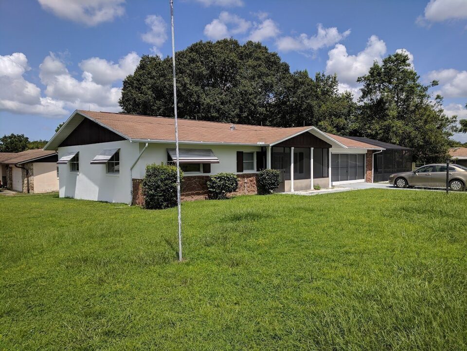 Single-story ranch home with a screened porch on a grassy lot in Beverly Hills.