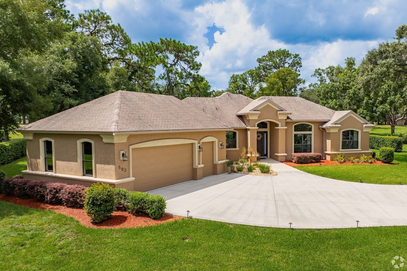 Custom one-story home with arched entry and three-car garage on a landscaped Citrus Hills lot.
