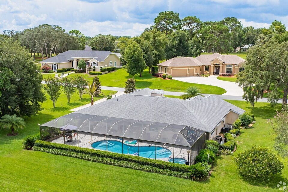 Aerial view of a screened-pool home in Citrus Hills, with neighboring homes on a quiet wooded street.