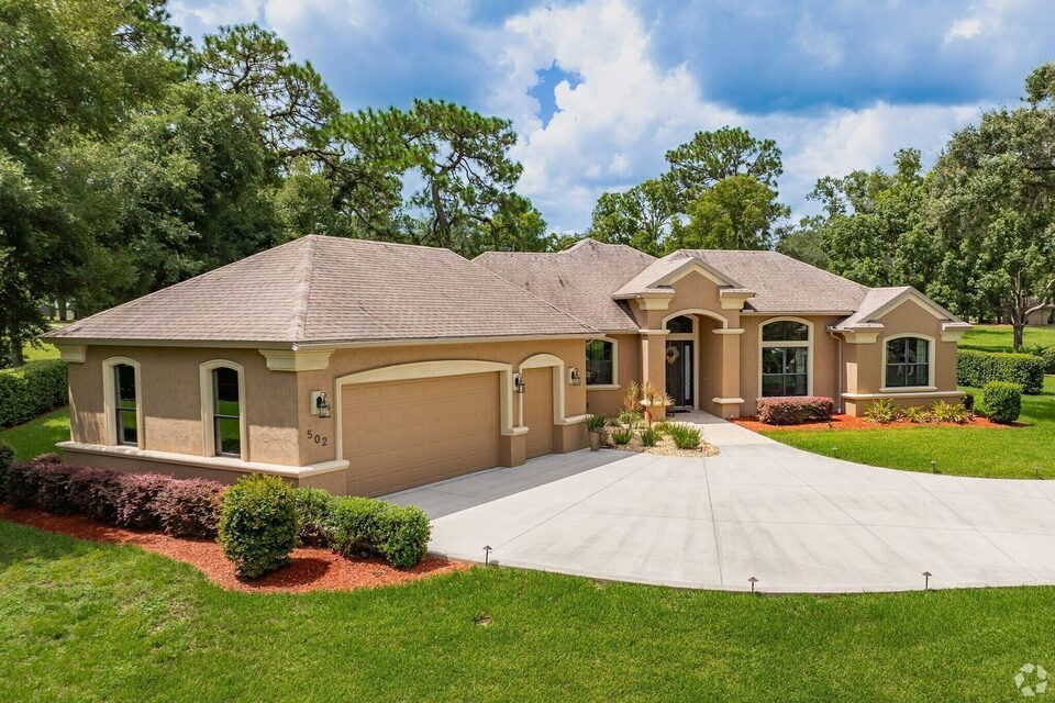 Custom one-story home with arched entry and three-car garage on a landscaped Citrus Hills lot.