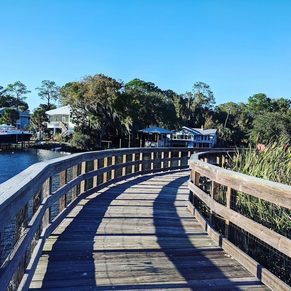 Wooden boardwalk curving along the spring-fed waterfront at Hunter Springs Park in Crystal River.