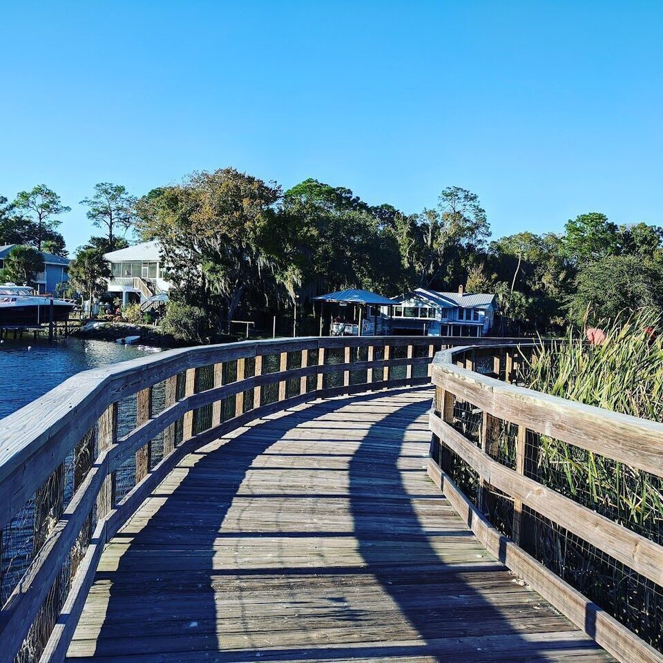 Wooden boardwalk curving along the spring-fed waterfront at Hunter Springs Park in Crystal River.
