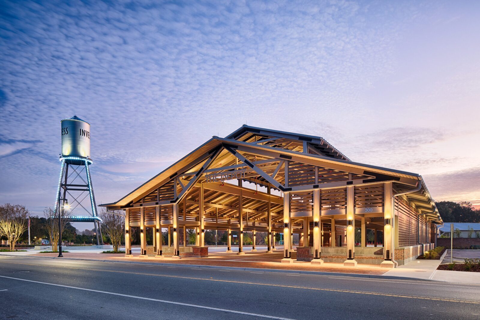 Inverness's downtown pavilion lit at dusk beside the historic INVERNESS water tower.