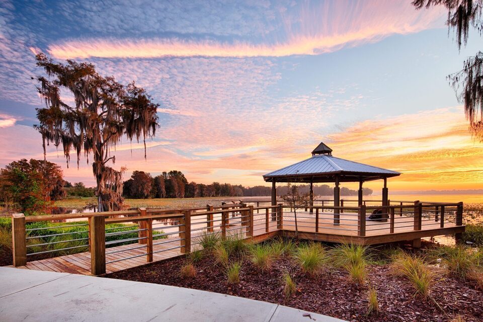 Lakeside gazebo at Liberty Park in downtown Inverness at sunset, with Spanish moss draping a cypress in the foreground.